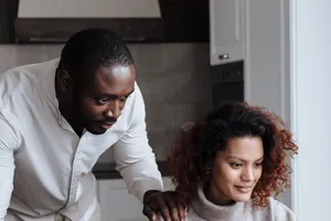 Couple planning together at a laptop in their kitchen